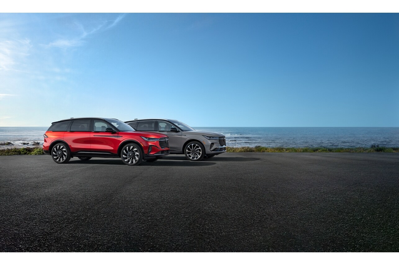 Two versions of the 2025 Lincoln Nautilus® SUV are parked near the ocean