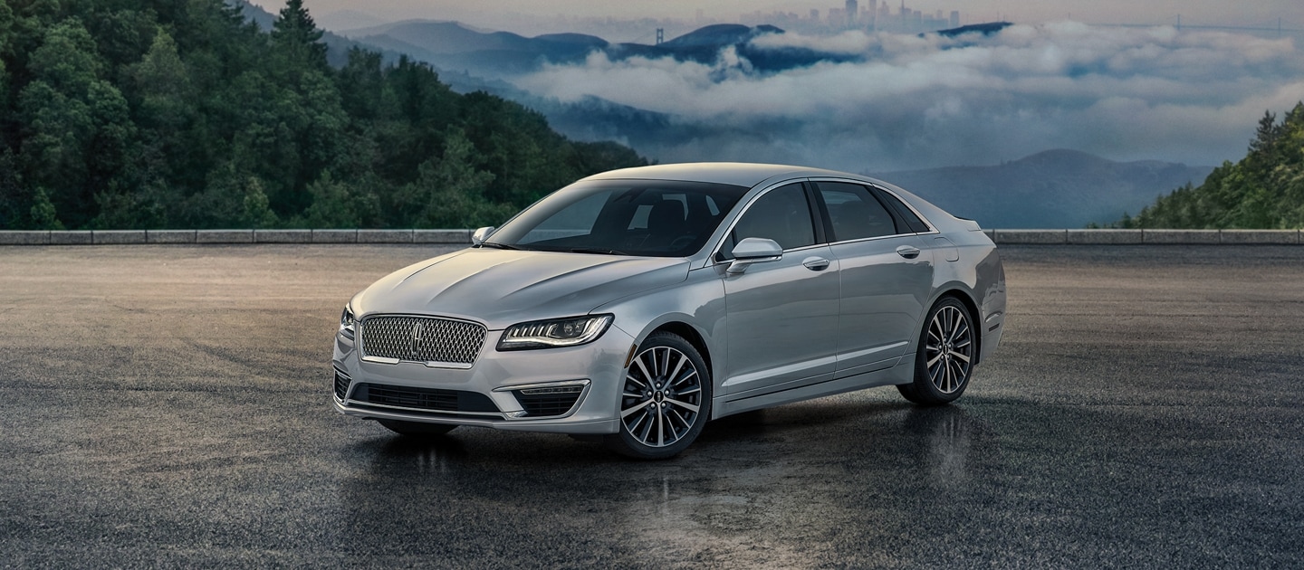 Un Lincoln MKZ estacionado en un mirador sereno arriba de las nubes con la silueta de rascacielos de fondo