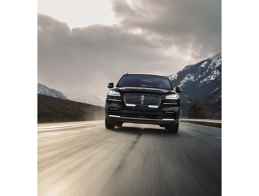 Se muestra una Lincoln Aviator andando por un camino mojado por agua de lluvia.