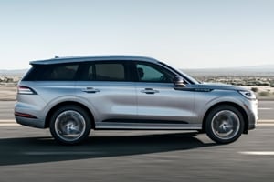 A Lincoln Aviator is being driven through a desert highway during the day