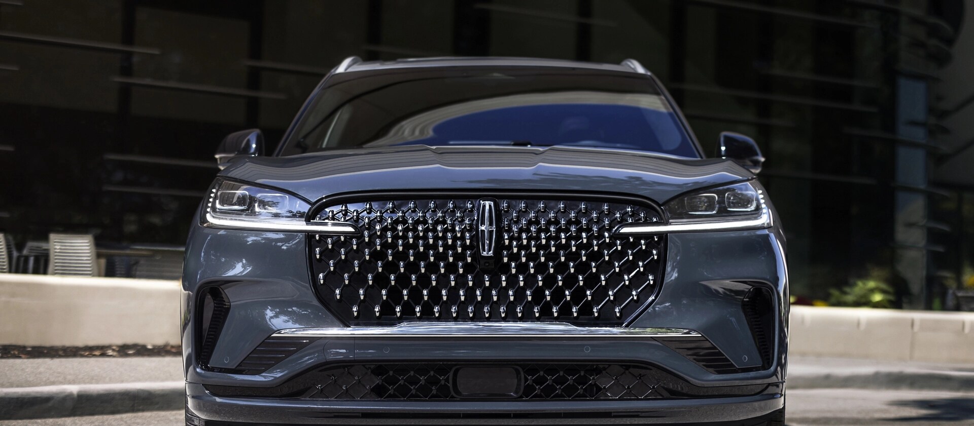 The dazzling grille of a 2025 Lincoln Black Label Aviator® SUV sparkles in the sunlight