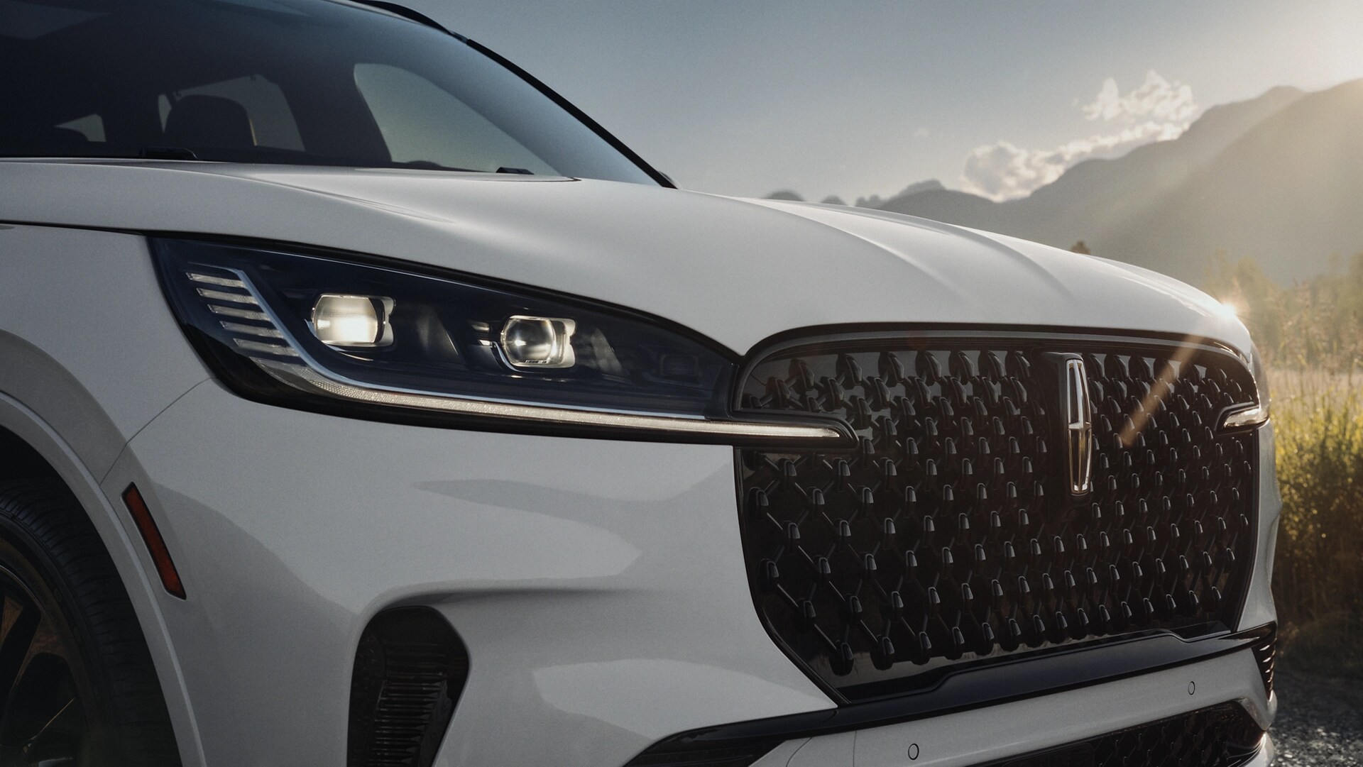 Portions of the grille of a 2025 Lincoln Aviator® are illuminated as part of the Lincoln Embrace.