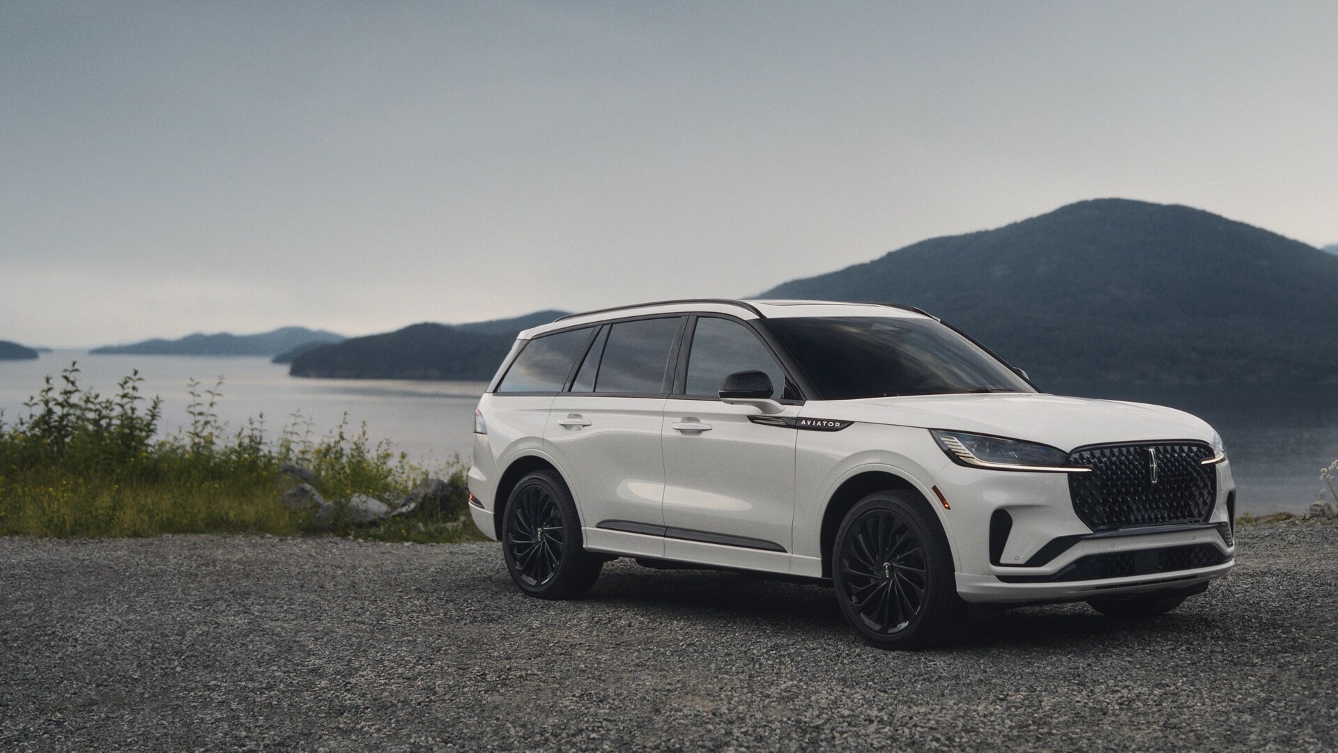A 2025 Lincoln Aviator® SUV is parked by a scenic lakeside overlook.