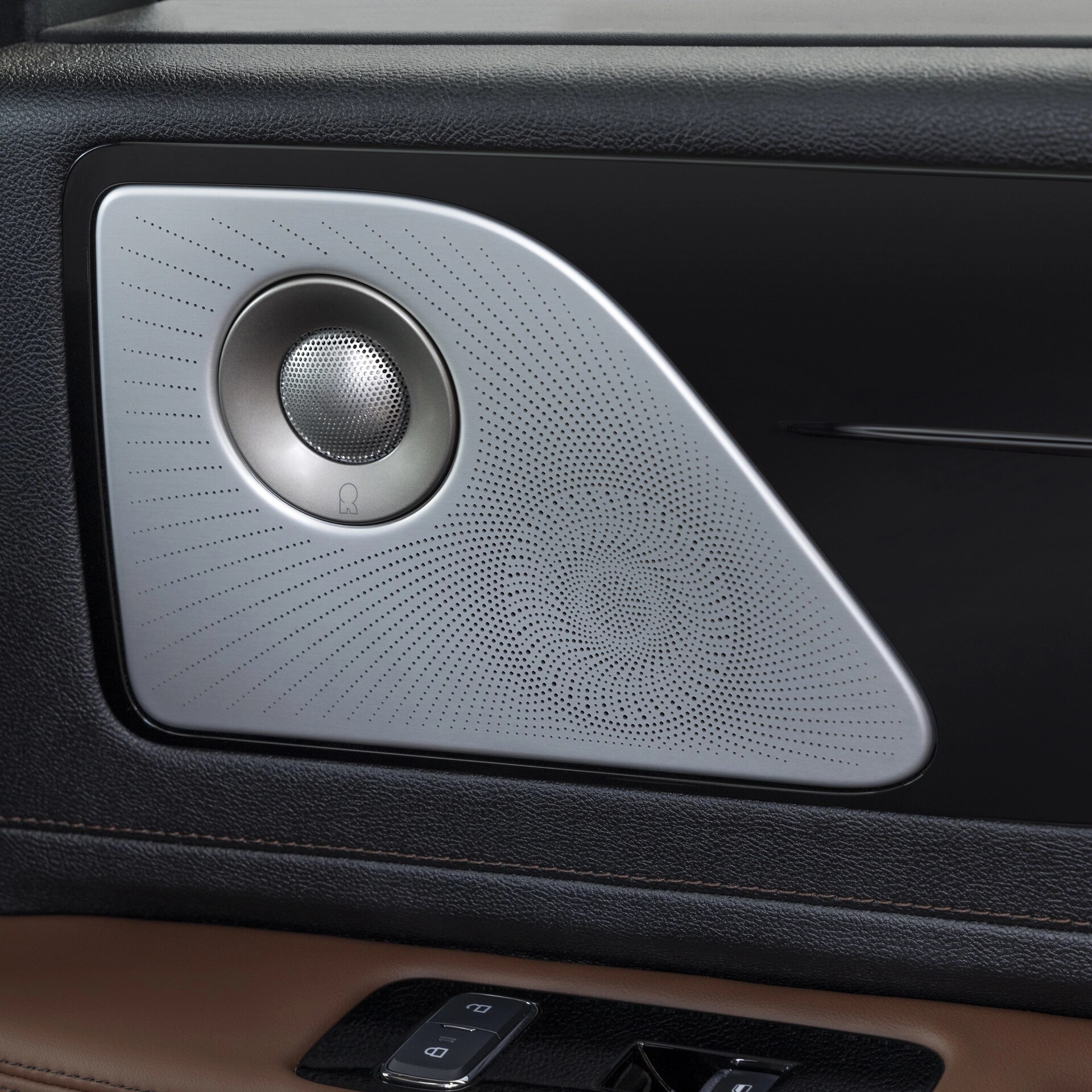 A Revel® speaker is shown on the interior door pane of a 2026 Lincoln Aviator® SUV