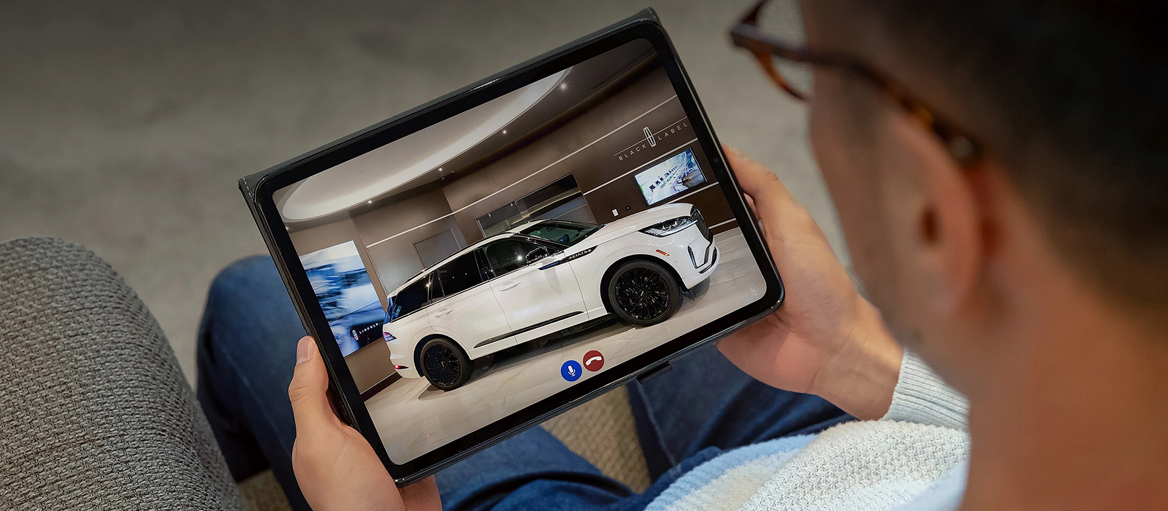 A person uses a tablet to take a live virtual tour of a Lincoln vehicle