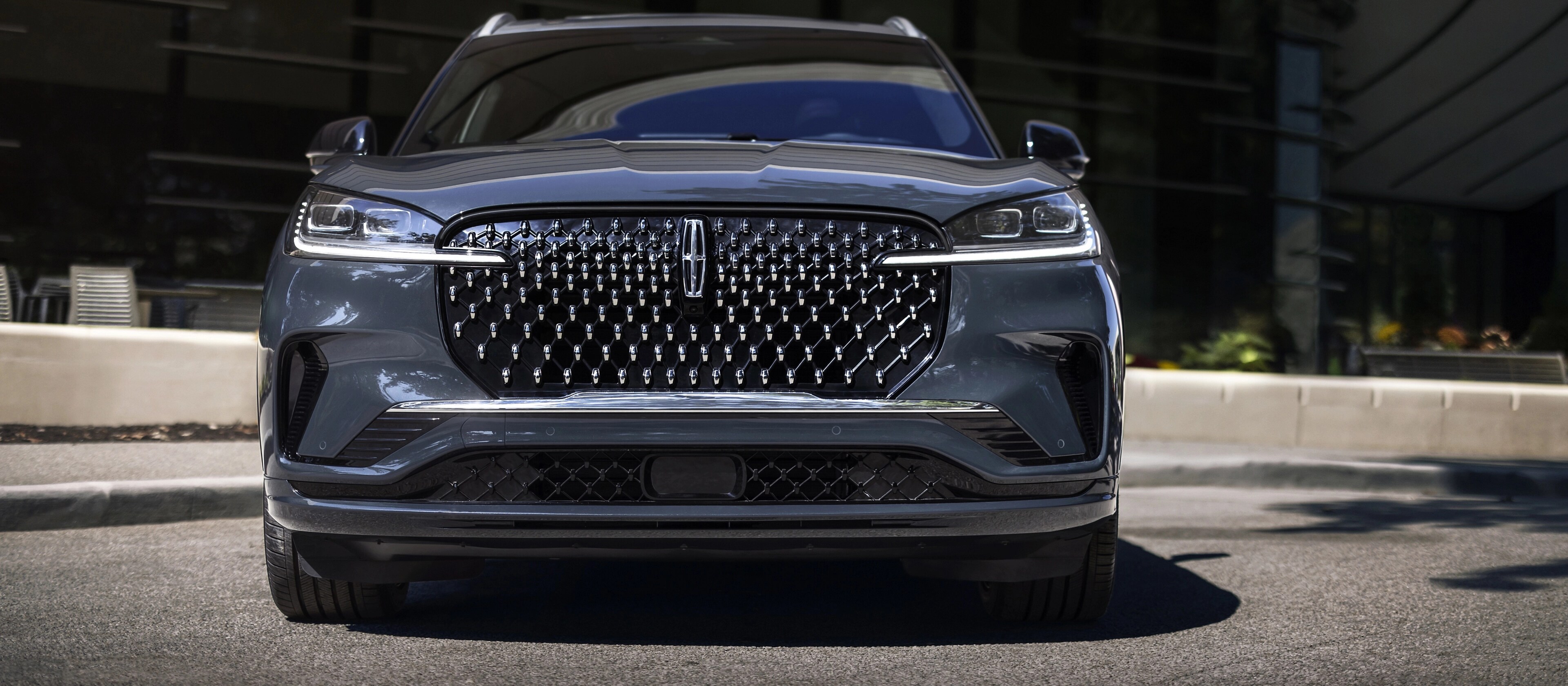 The dazzling grille of a 2026 Lincoln Black Label Aviator® SUV sparkles in the sunlight