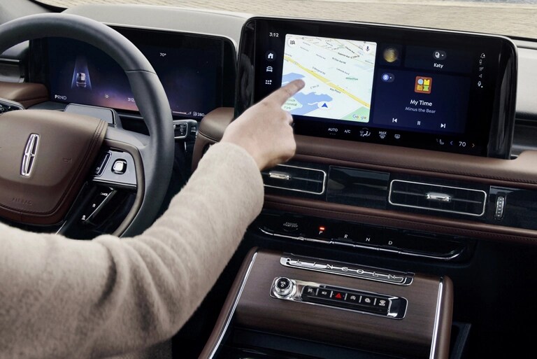 A person is tapping the center-stack touchscreen display of a 2026 Lincoln Aviator® SUV