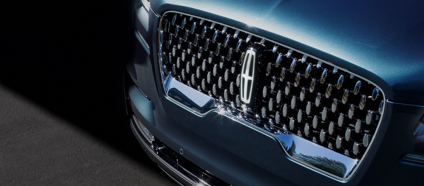 La parrilla de la Lincoln Aviator® Black Label 2023 se muestra con formas tipo estrella en relieve que rodean el emblema central de Lincoln