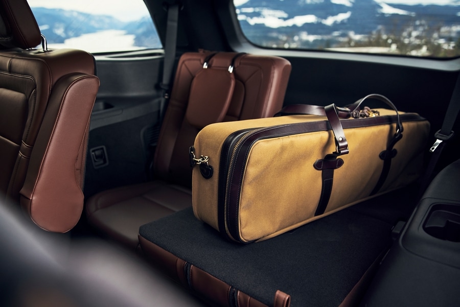 A large oblong bag is shown resting on one of the third-row seats of a 2023 Lincoln Aviator® which have been folded flat