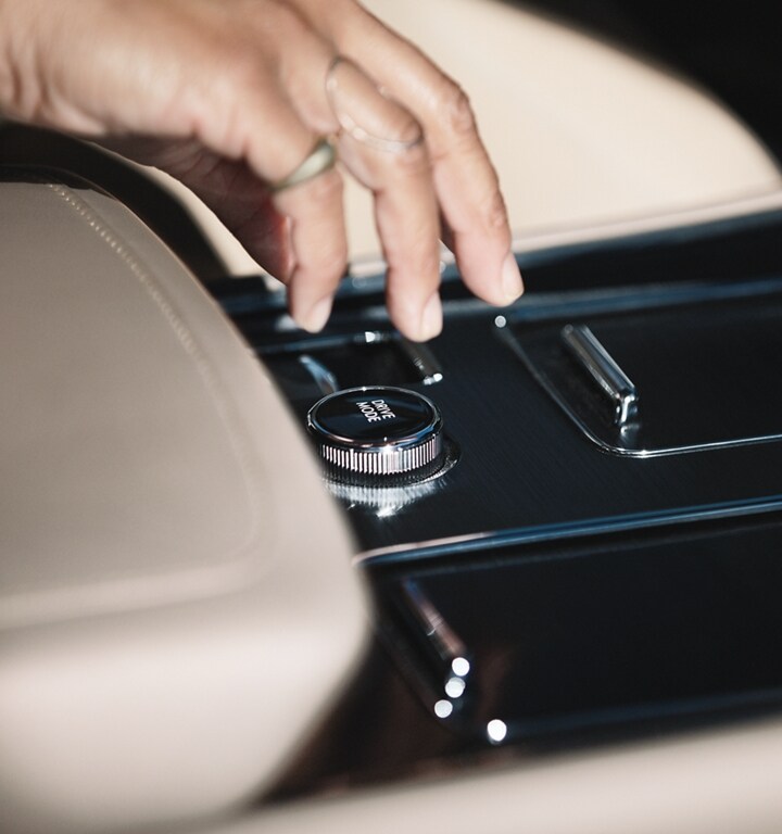 A hand is shown reaching for the knob that helps drivers easily switch from among up to 7 unique drive modes in a 2023 Lincoln® Aviator