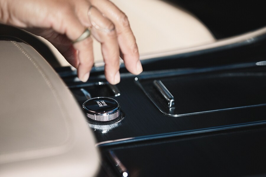Se muestra la mano de una persona que está por tomar la perilla de modos de manejo en la consola central de una Lincoln Aviator® 2023