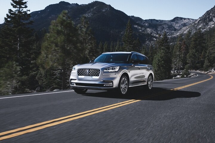 Se muestra un modelo Lincoln Aviator®​​​​​​​ Grand Touring 2023 andando por un camino de montaña