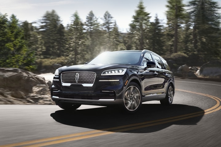 A 2023 Lincoln Aviator® is shown being driven through a tight mountain turn