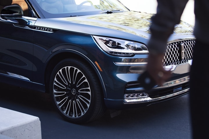 A driver is shown approaching a 2023 Lincoln Aviator® holding a phone that can act as a key