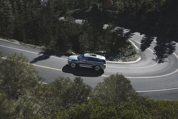 Se muestra una Lincoln Aviator® 2023 desde arriba mientras recorre un camino de montaña sinuoso