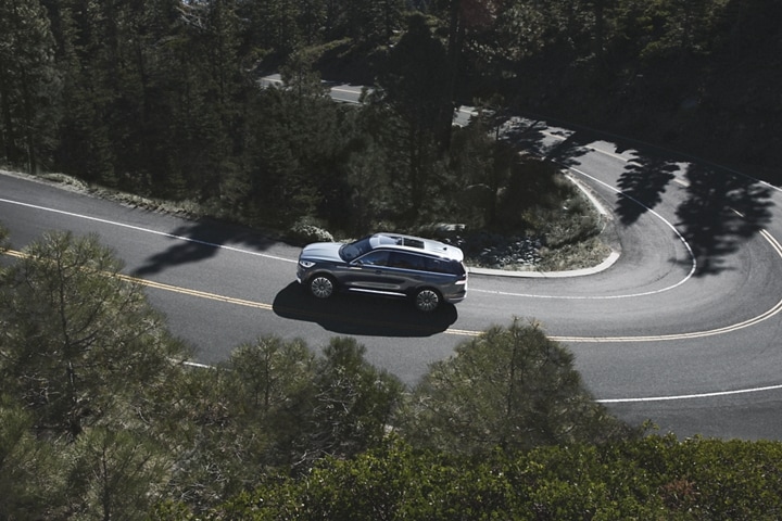 A 2023 Lincoln Aviator® is shown from above as it travels along a winding mountain road