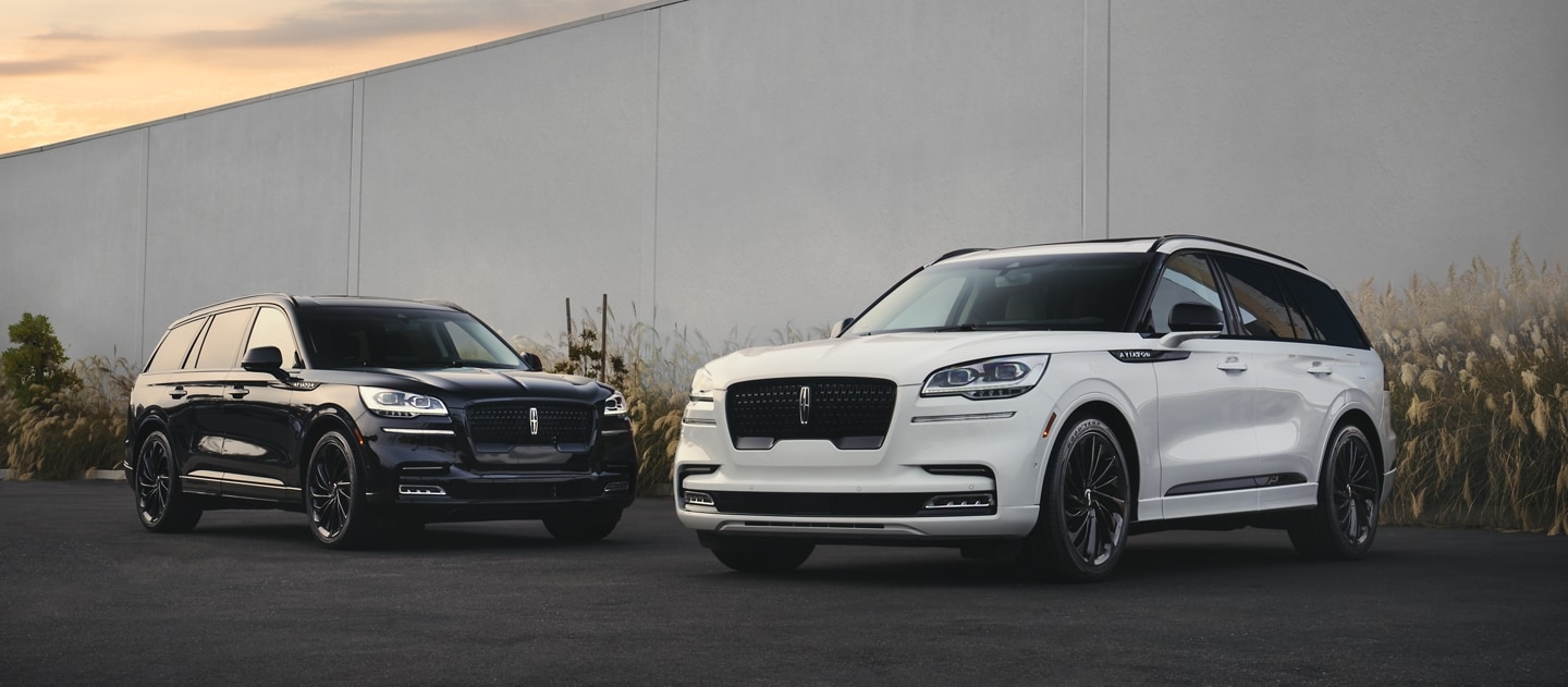 Two 2023 Lincoln Aviator® SUVs are shown with the available Pristine White and Infinite Black Jet Appearance Package