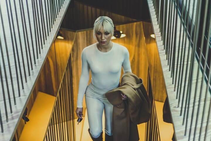 Se muestra una mujer subiendo las escaleras de un moderno chalet