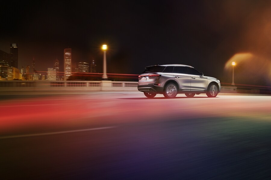 A 2021 Lincoln Corsair is being driven through an urban setting at night with responsive performance