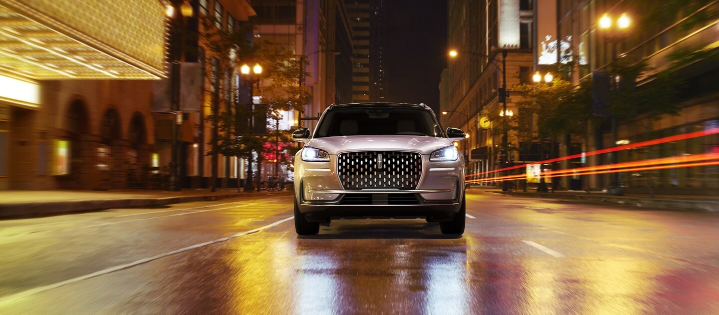Se muestra una SUV Lincoln Corsair® 2023 andando por una calle de ciudad de noche