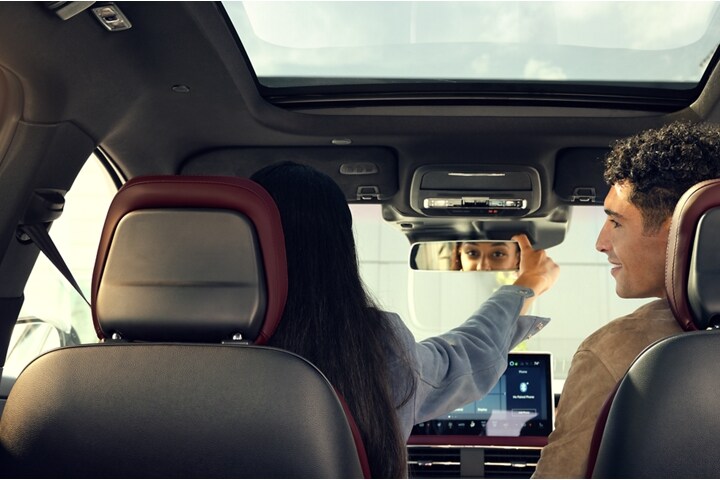El conductor de una SUV Lincoln Corsair® 2023 acomoda el espejo retrovisor sin marco