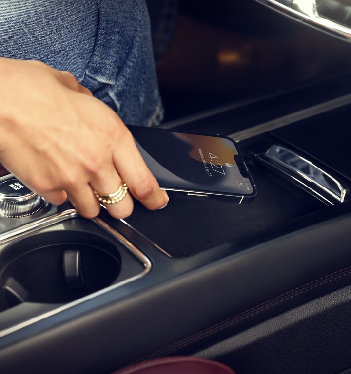 A mobile phone is being placed on the wireless charger of a 2023 Lincoln Corsair® SUV