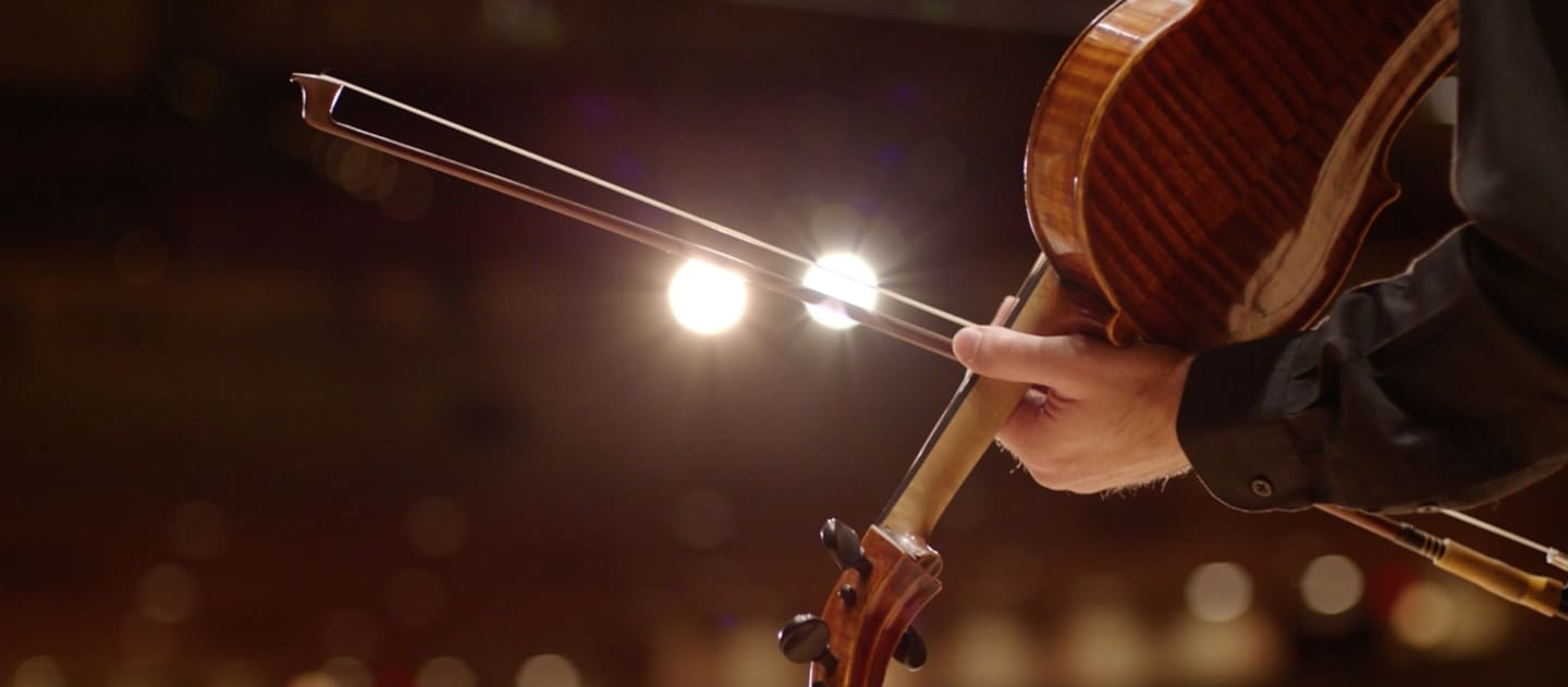 A bow slides across a violin to illustrate the dramatic sound of the in-vehicle chimes
