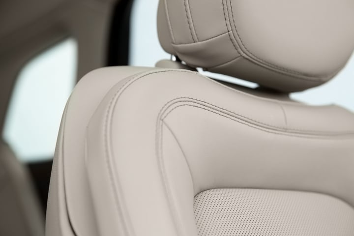 A detail shot of a leather-trimmed Perfect Position front seat shows details like luxe materials and precision stitching