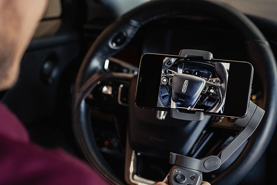 A Lincoln representative uses a smartphone to conduct a private showing of a Lincoln vehicle