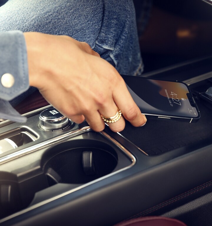 A mobile phone is being placed on the wireless charger of a 2024 Lincoln Corsair® SUV