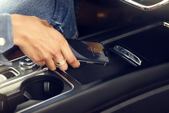 Una persona colocando un smartphone en la base de carga inalámbrica disponible de una SUV Lincoln Corsair® 2024