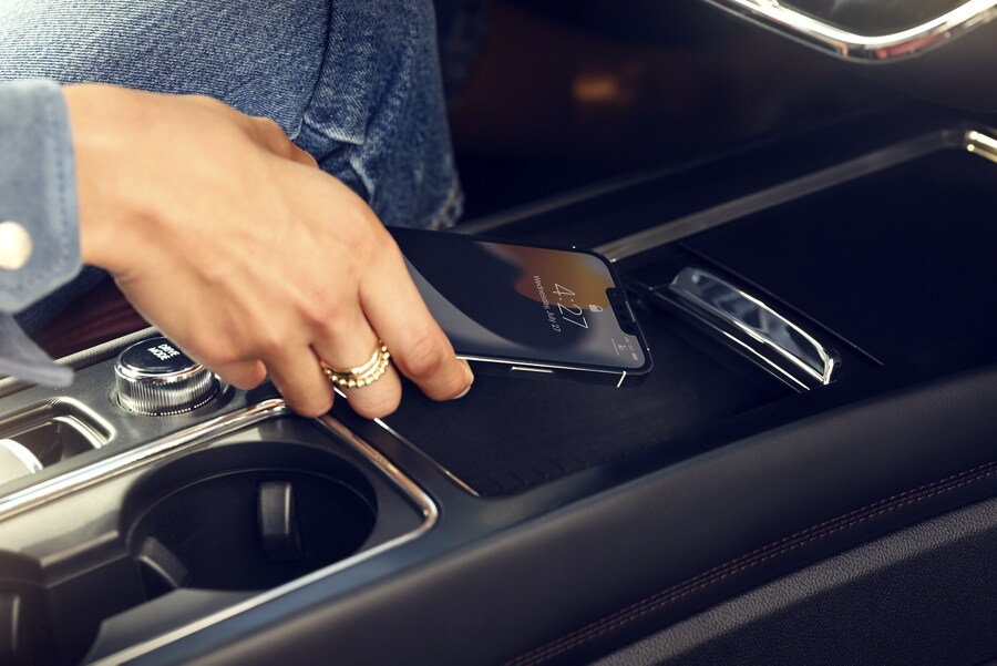 A mobile phone is being placed on the wireless charger of a 2024 Lincoln Corsair® SUV