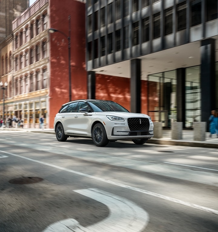 A 2024 Lincoln Corsair® SUV with the Jet Appearance Package is being driven in the city