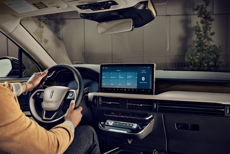 A person is shown sitting in the driver’s seat of a 2024 Lincoln Corsair® while adjusting their personal profiles settings