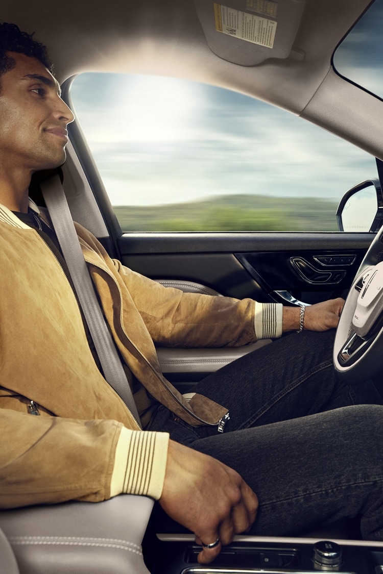 A person shown in the driver’s seat of a 2024 Corsair® SUV while using ActiveGlide™ 1.2