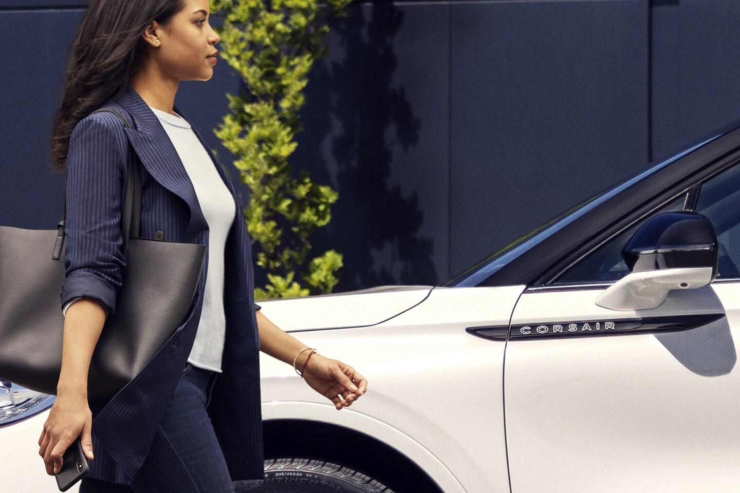 A person approaches a 2025 Lincoln Corsair® Reserve model while holding a mobile phone