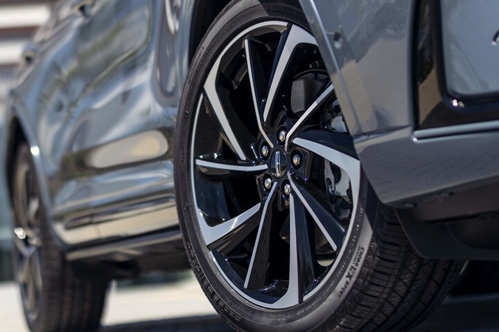 The available 20-inch aluminum wheels with black premium paint are shown on the Grand Touring model