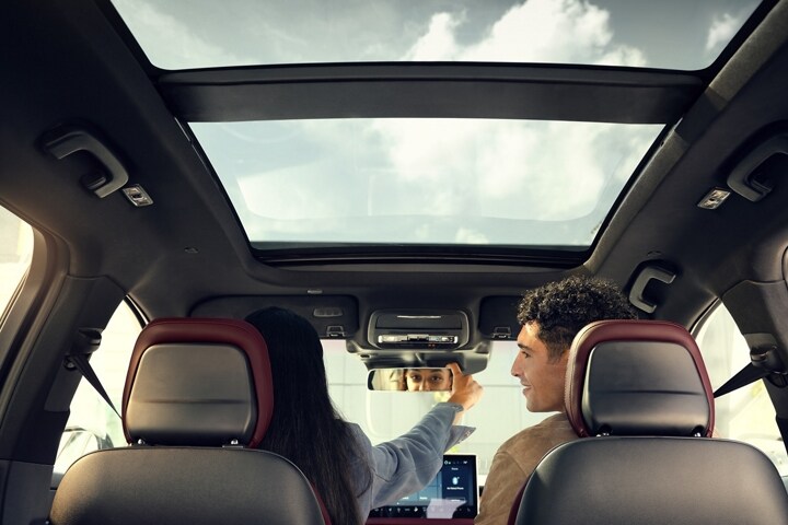 The driver of a 2025 Lincoln Corsair® Reserve model adjusts the frameless rearview mirror