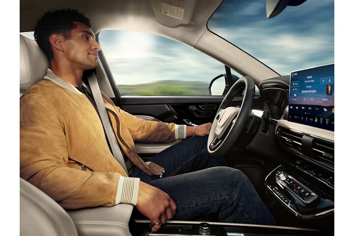 A driver enjoys using Lincoln BlueCruise hands-free restricted access divided highway driving