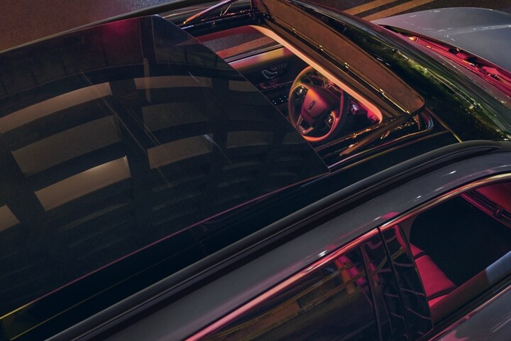 Neon light pours through the available panoramic Vista Roof® of a 2025 Lincoln Corsair® SUV