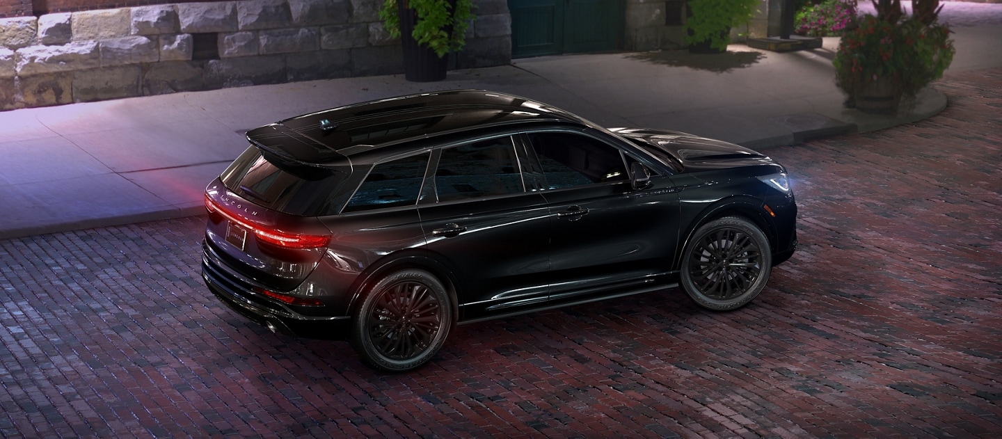 Una SUV Lincoln Corsair® 2025 estacionada en una calle de ladrillos, de noche.