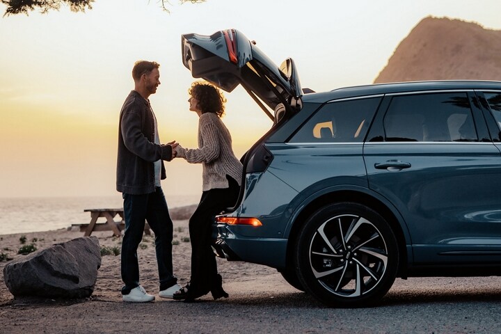 A woman with her hands full makes use of the available hands-free power liftgate