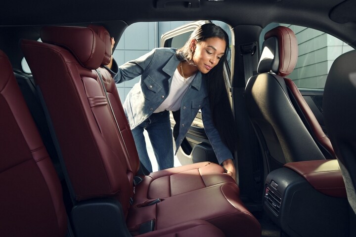 A woman repositions the sliding second-row seats of a 2026 Lincoln Corsair® SUV
