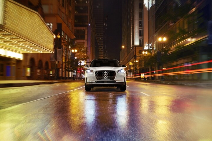 Environmental neon light bounces off the grille of a 2026 Lincoln Corsair® Reserve SUV