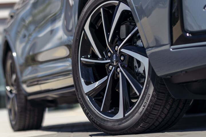 The available 20-inch aluminum wheels with black premium paint are shown on the Grand Touring model
