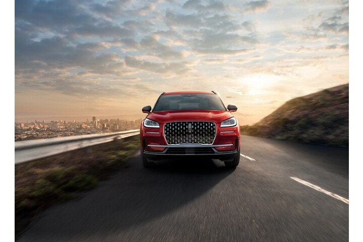 2026 Lincoln Corsair® SUV is being driven on a mountain road with a city in the background