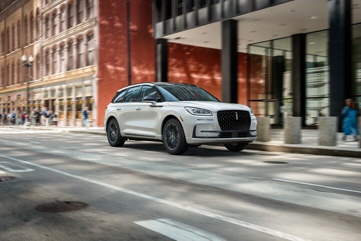 A 2026 Lincoln Corsair® Reserve model with the Available Jet Appearance Package is being driven in a city setting