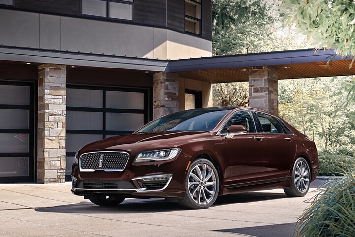 The 2020 Lincoln M K Z shown in Magma Red is shown parked in the driveway of an elegant home