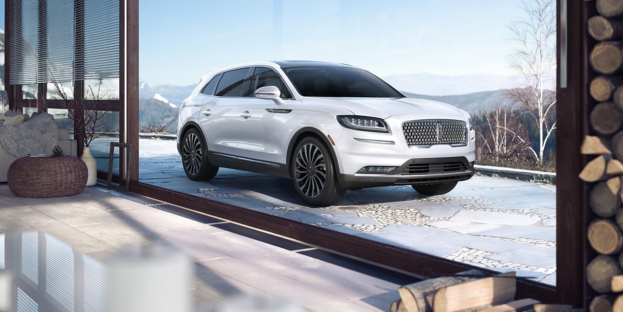 A 2022 Lincoln Black Label Nautilus in the Chalet theme is shown parked in the driveway of a luxurious mountain home
