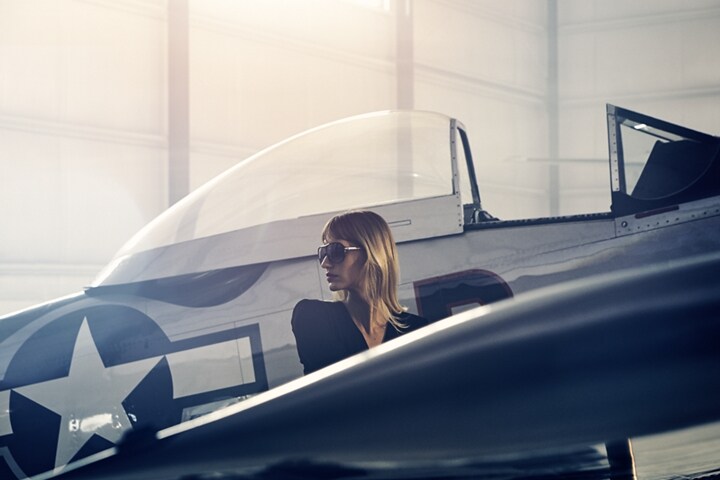 Se muestra una mujer esperando debajo del ala de un avión privado antiguo